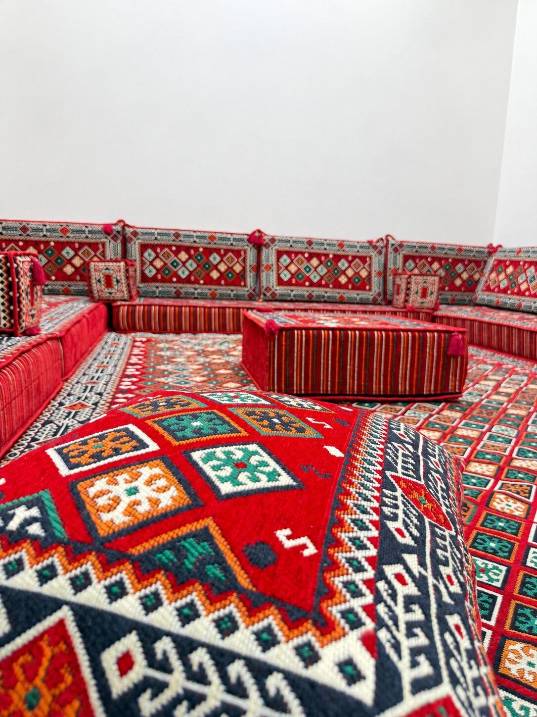 Close-up of the heavy red Sahrawi fabric with green, black and ivory diamond motifs