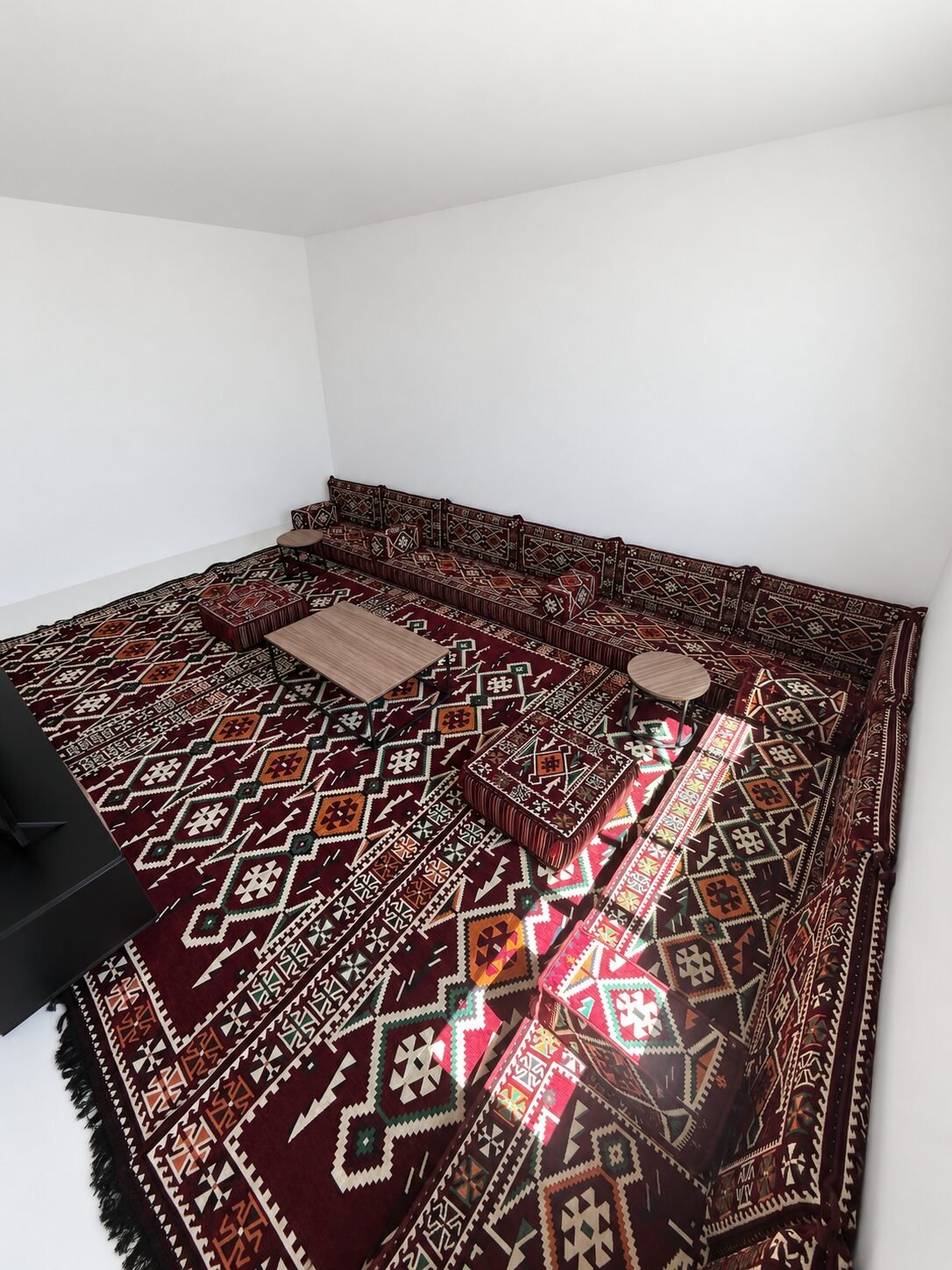 Burgundy Sahrawi majlis seating along two walls