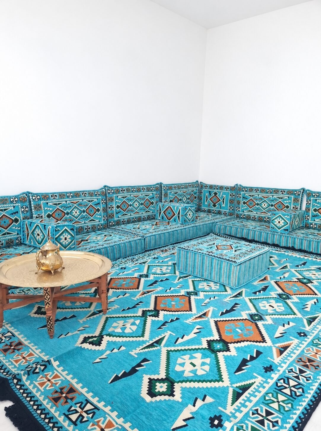 Turquoise Moroccan majlis around a brass tea table
