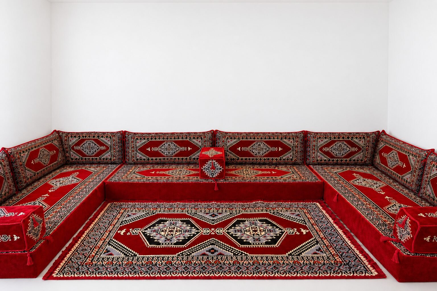 Imlili ruby red Sahrawi majlis with a medallion rug in a white room