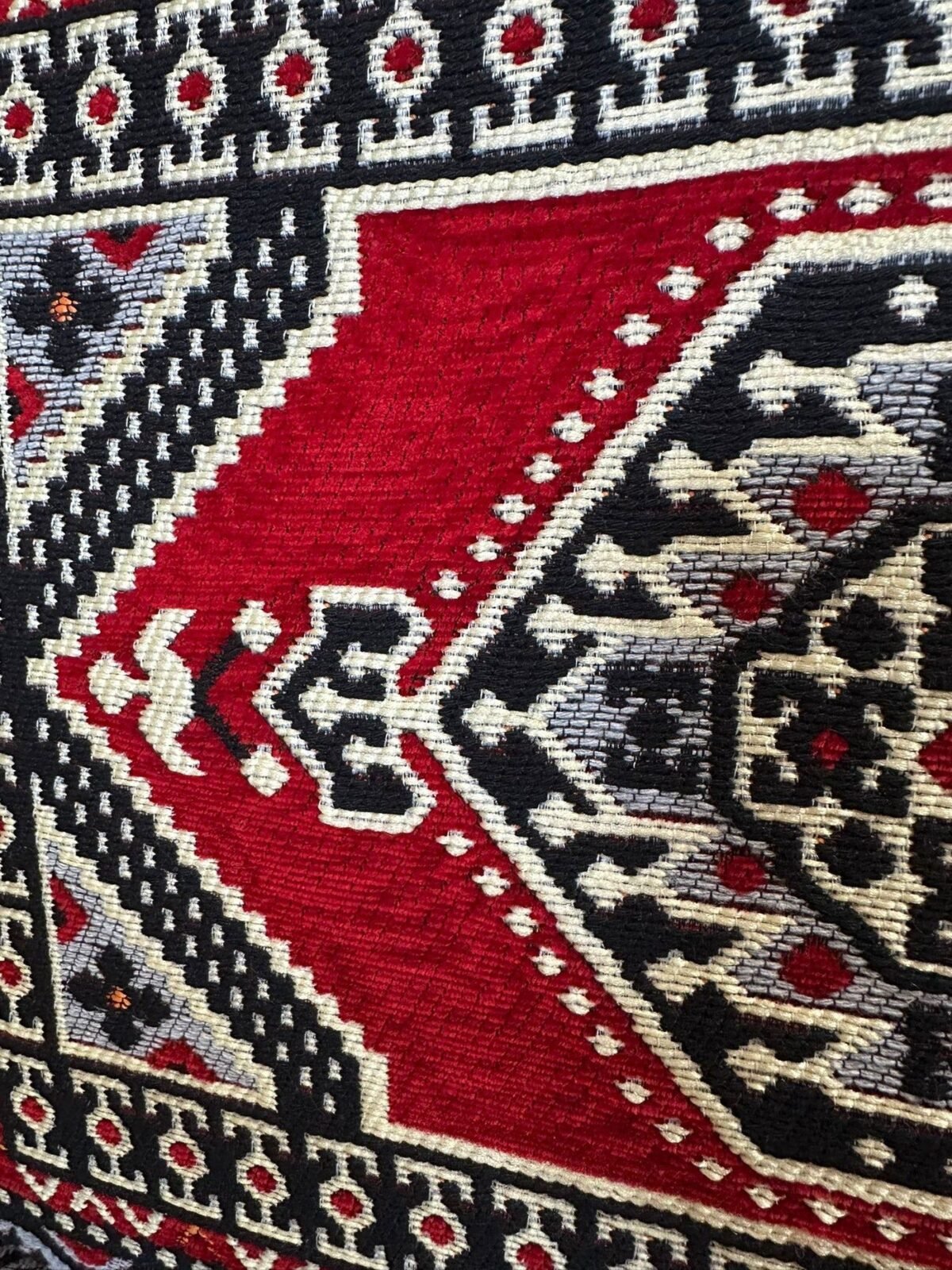 Close-up of the ruby red Sahrawi fabric with black and ivory medallion