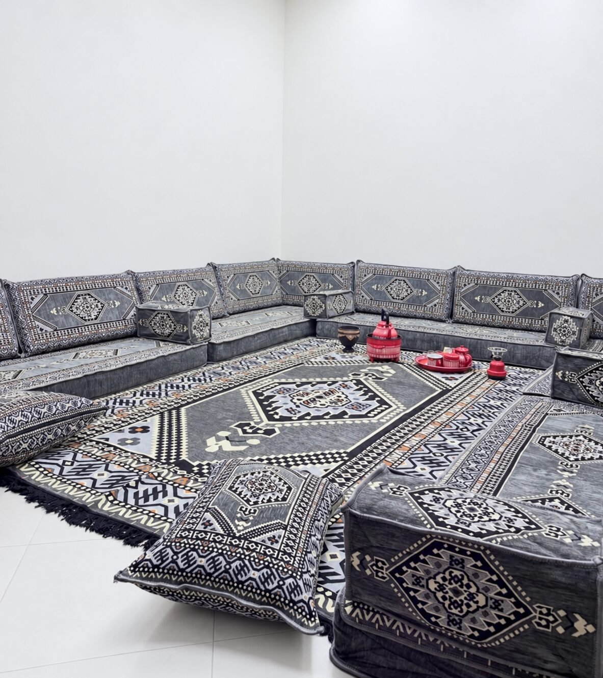 Grey Sahrawi majlis seat with a red tea set