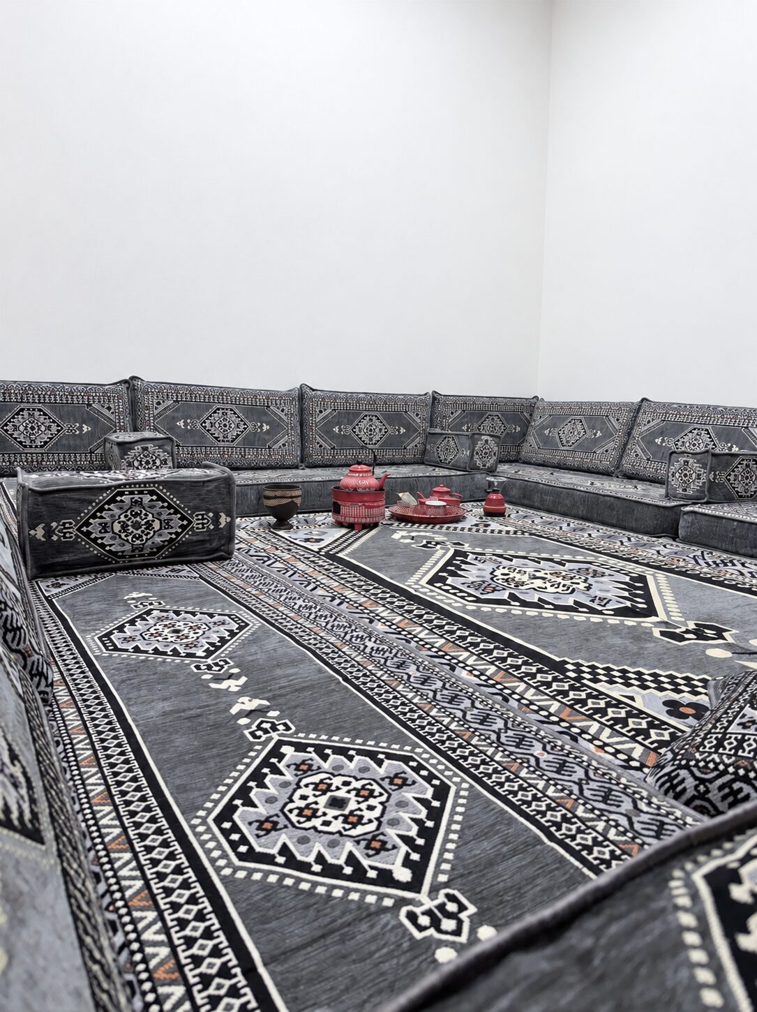 Red tea glasses on the grey patterned majlis