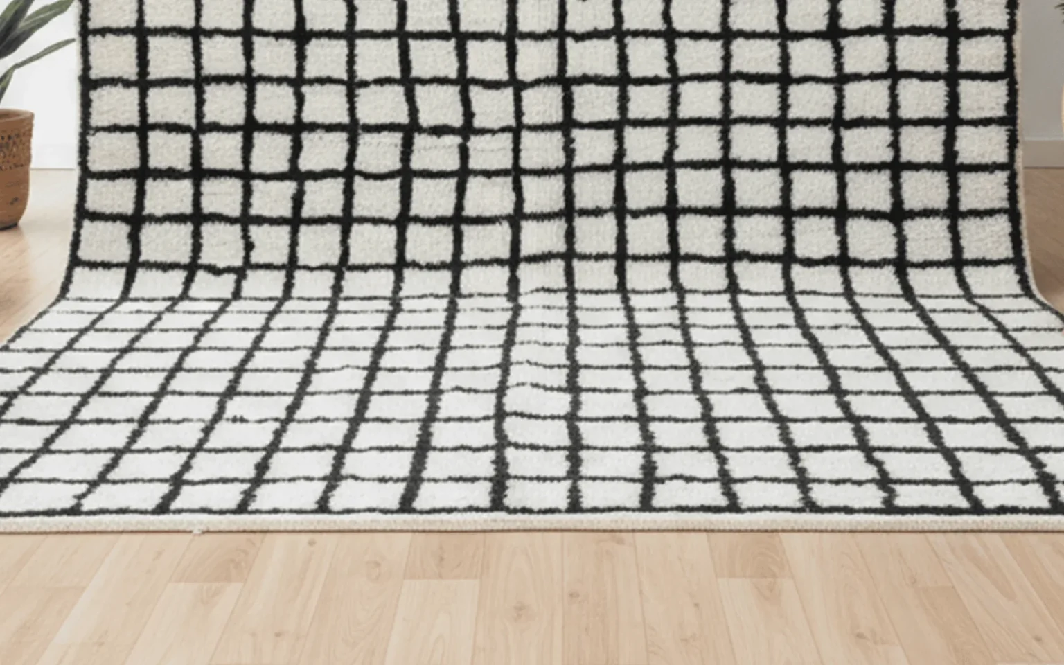 Close-up of a handwoven ivory wool rug with an irregular hand-drawn black grid, showing the uneven lines of hand knotting.