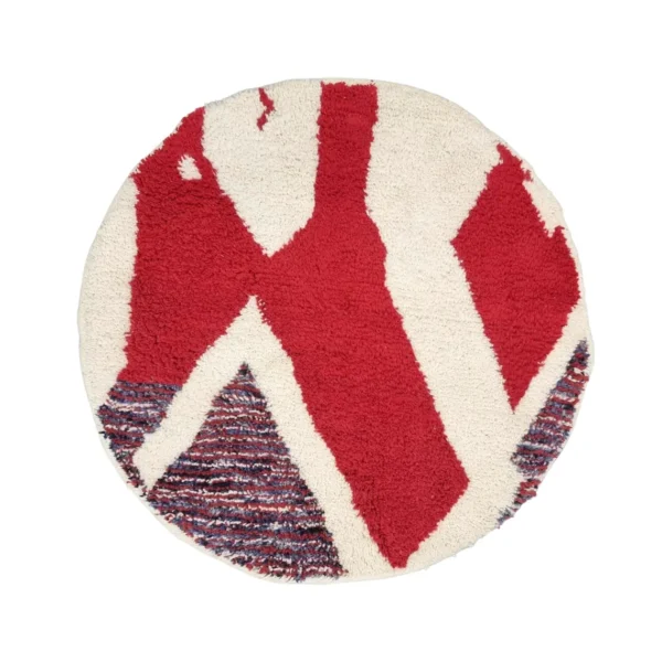 Round handmade Moroccan wool rug with bold red abstract shapes on ivory and a striped red, blue and ivory triangle