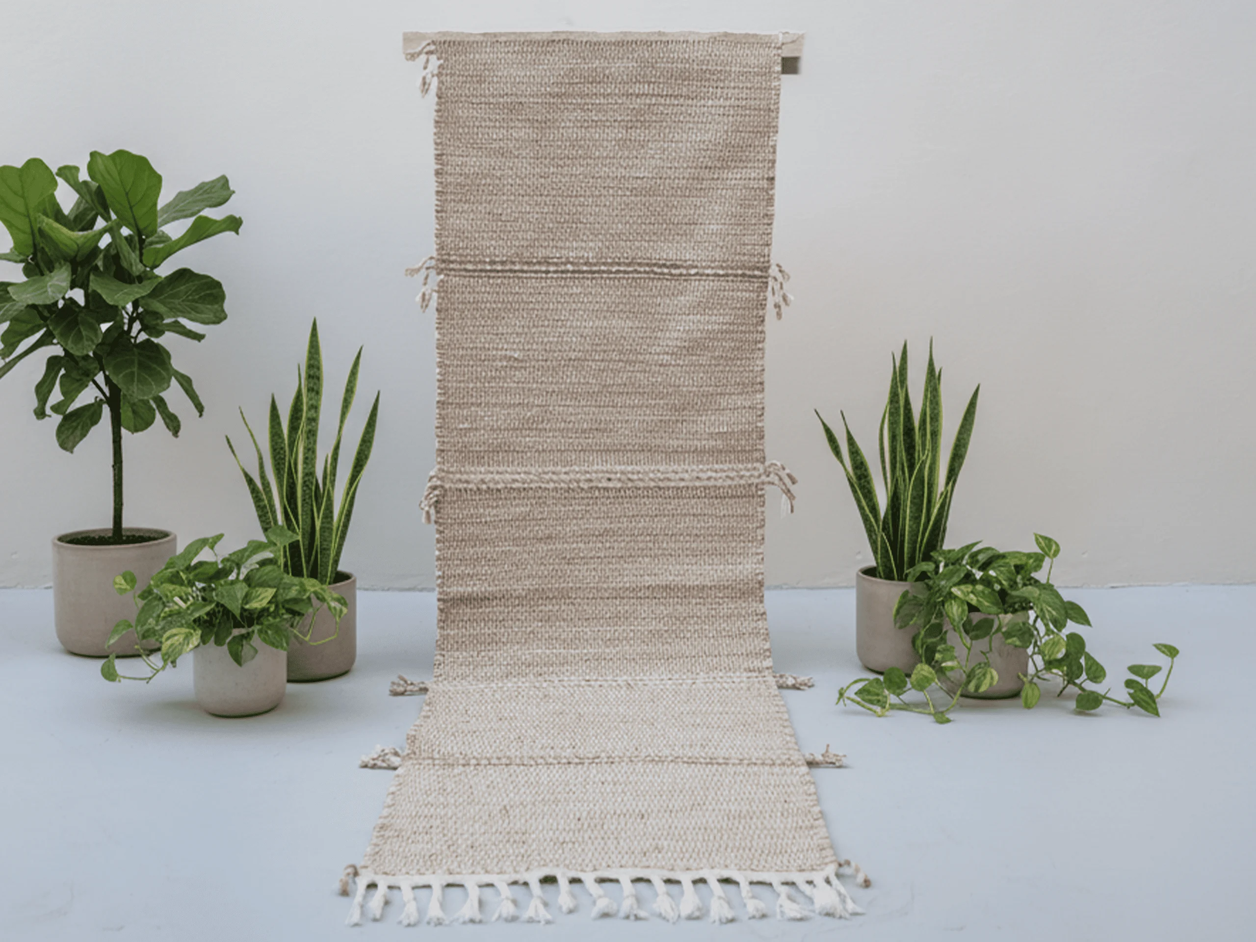 Beige Zanafi Moroccan runner rug displayed vertically, showing subtle horizontal bands, side tassels and ivory fringe.