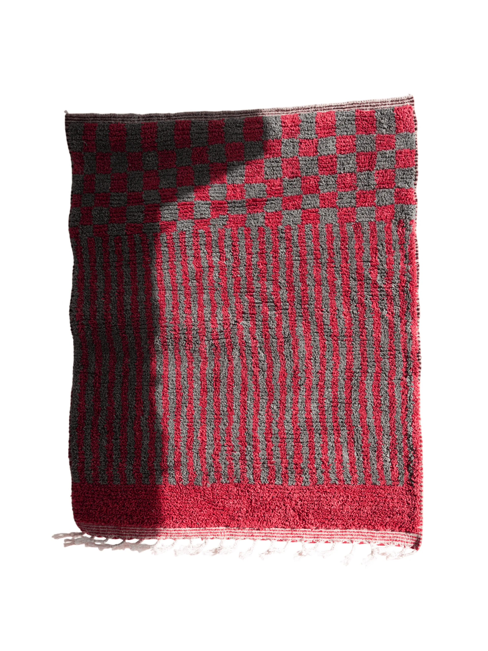 Full top view of a red and charcoal Boujaad-style wool rug with a checkerboard section, narrow stripes and a broad red end band.