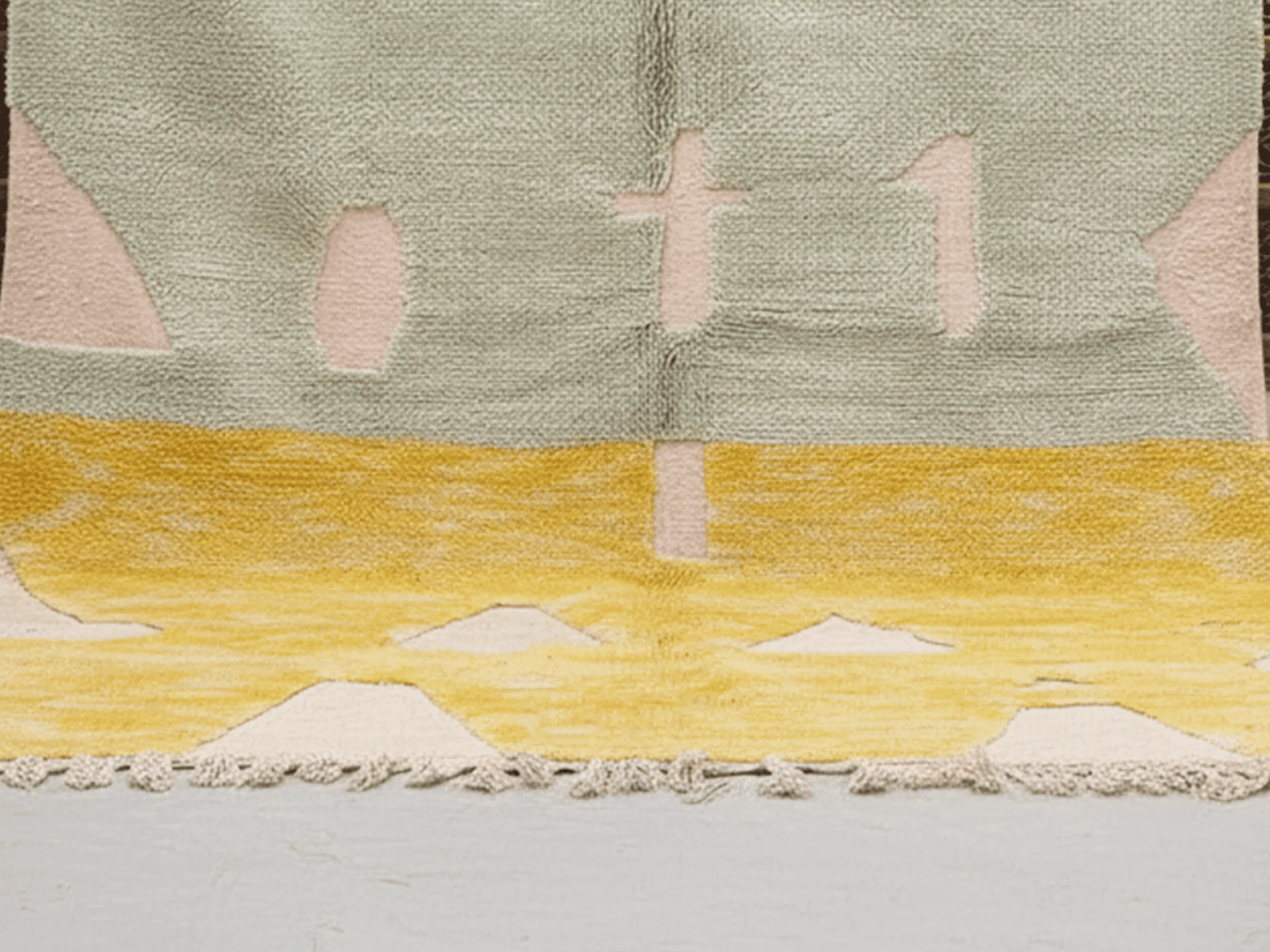 Closer view of the meeting point between the sage green and golden yellow wool fields with cream abstract shapes.