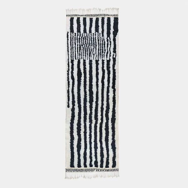 Black and ivory striped wool runner on a light gray background, with a panel of fine cross-lines near the top and fringe at both ends.