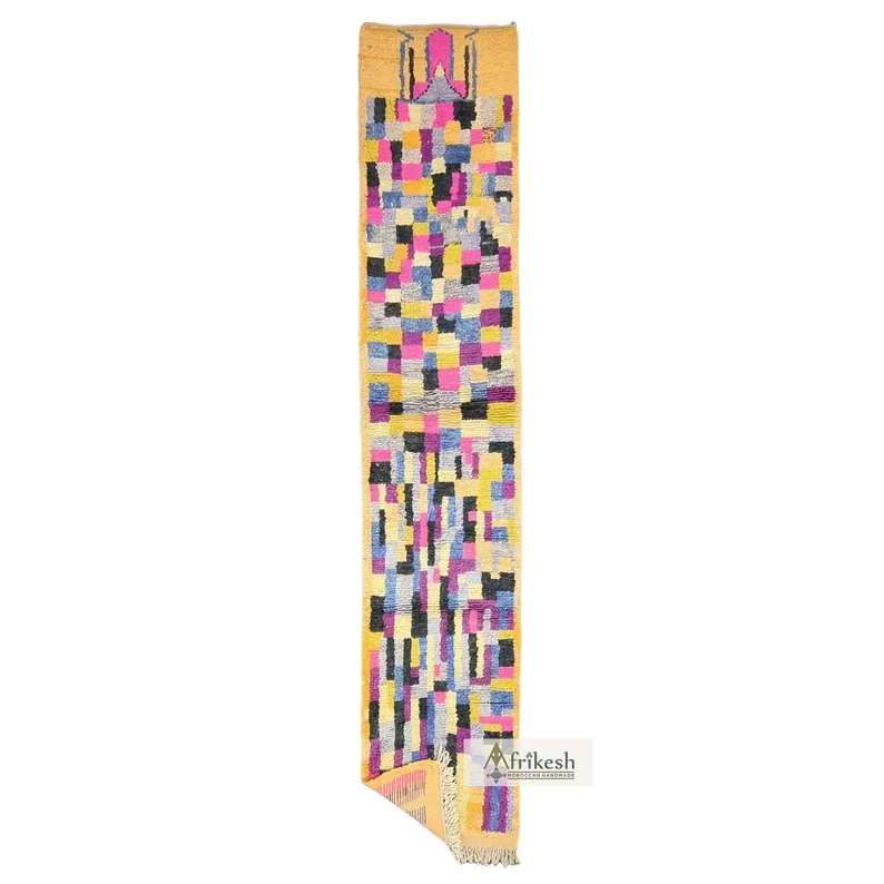 Long wool runner on a white background with multicolor patchwork blocks inside an apricot border and a pink motif at the top.