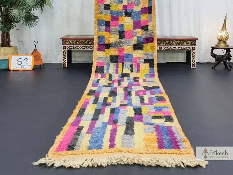 Lower part of the patchwork runner spread toward the camera on a dark floor, with ivory fringe.