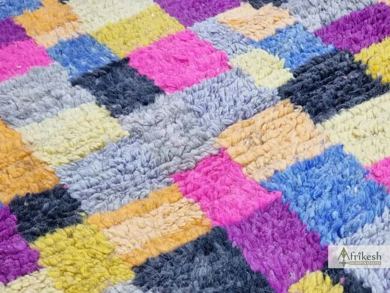 Close-up of shaggy wool blocks in pink, blue, gray, yellow, purple and charcoal.