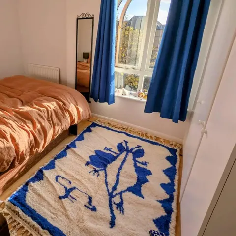 A handwoven Moroccan rug in a bedroom.