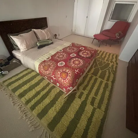 A handwoven Moroccan rug in a bedroom.